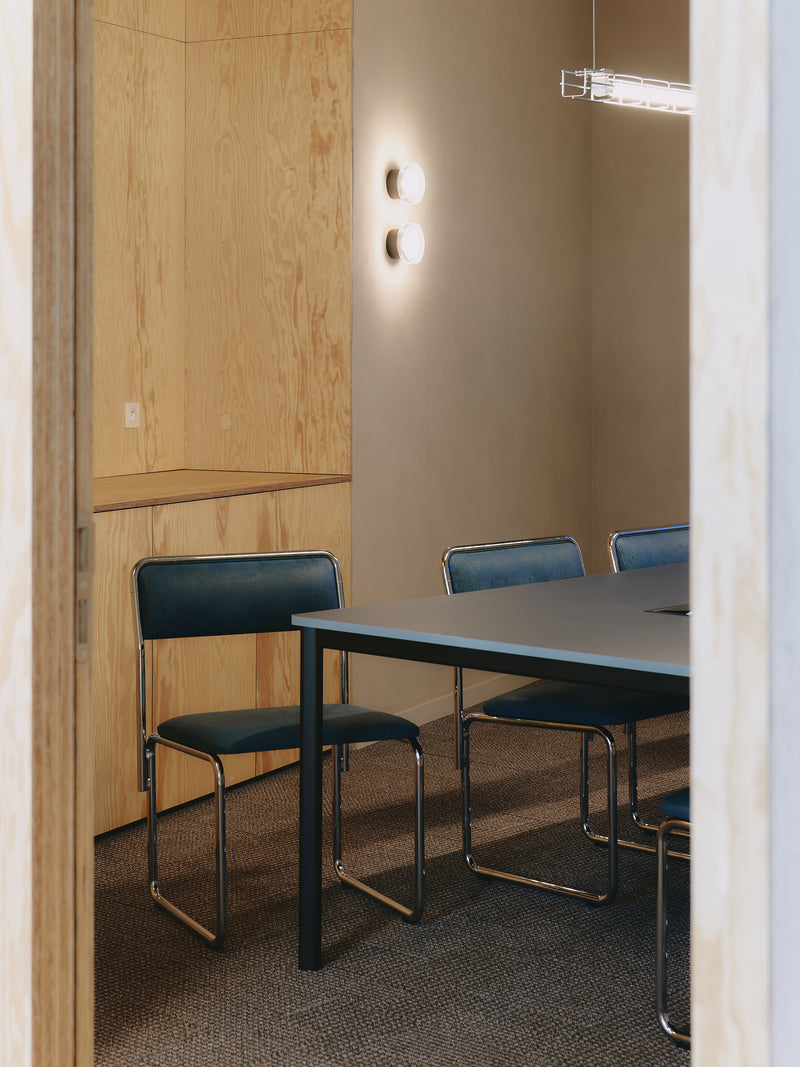 Small meeting room with a table and chairs in a neutral setting
